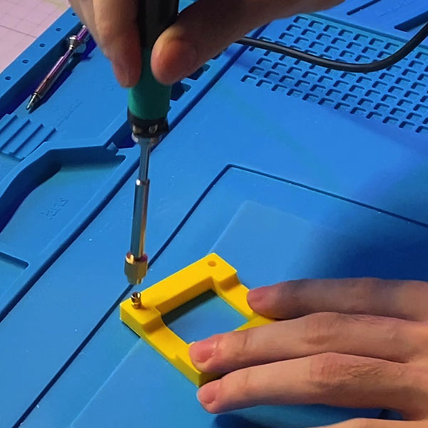 Using soldering iron to insert heat set inserts. Fun!